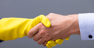 Businessman And Janitor Shaking Hands Together
